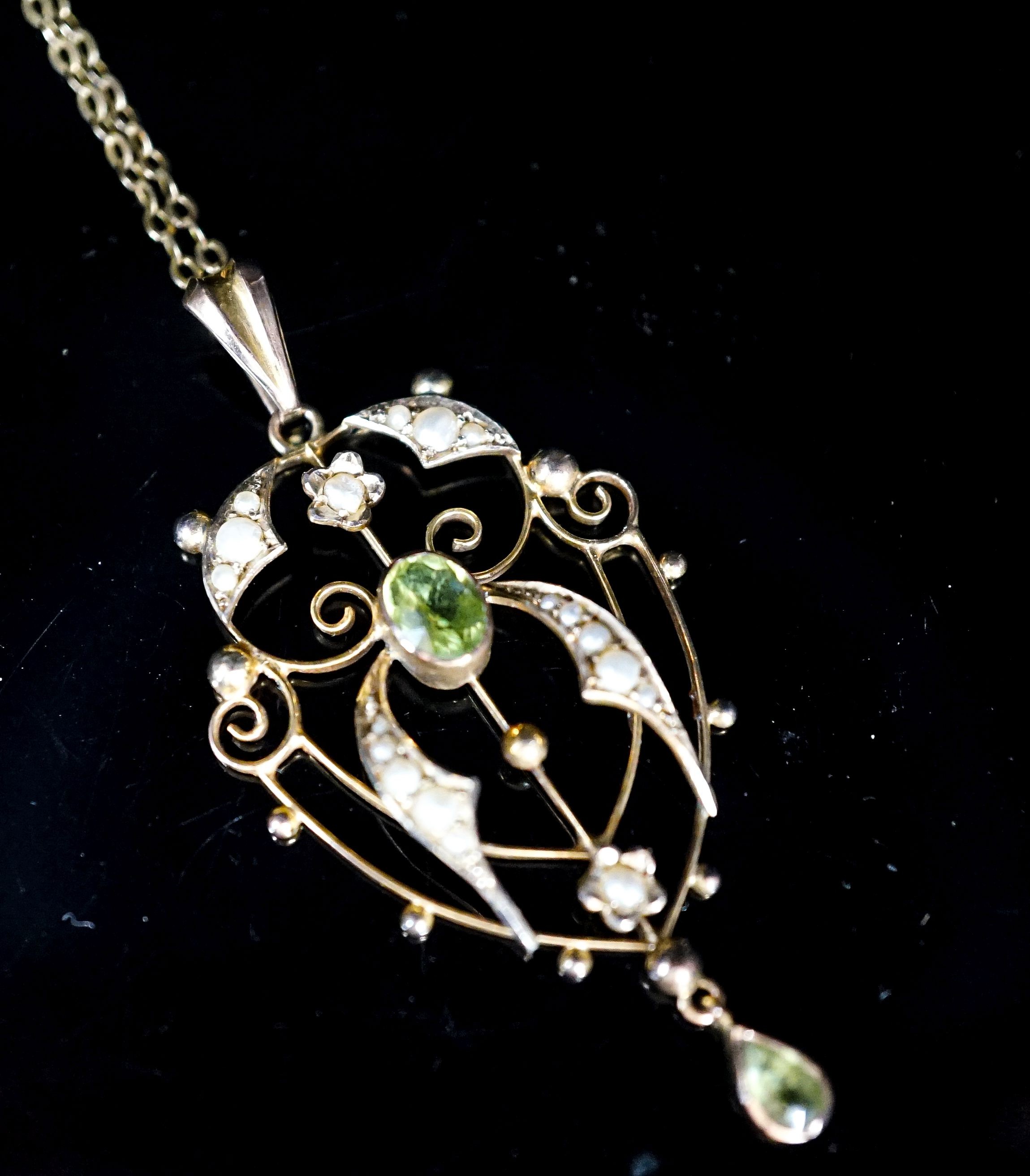 An Edwardian 9ct, peridot and seed pearl set drop pendant, 42mm, on a 9ct chain, 49cm